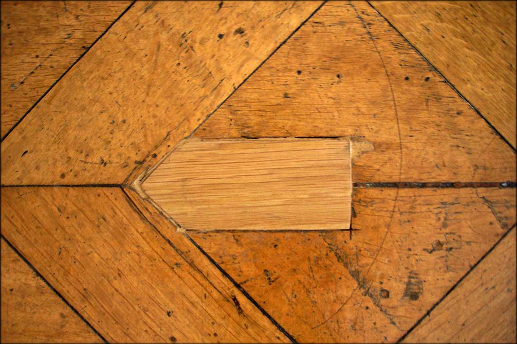 für das Restaurieren eines Tafelparketts aus massivem EichenholzSchadensbild: unsachgemäß eingefügte Holzergänzung